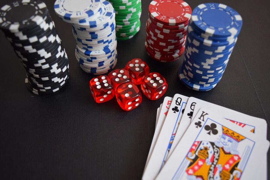 chips, dice and cards lay on a black surface